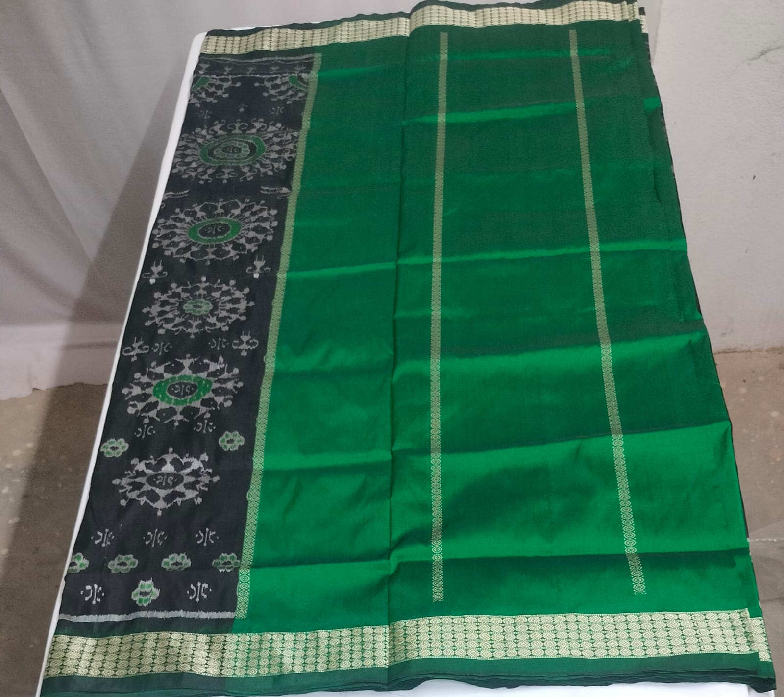Emerald green silk, adorned with black and green circular ikat motifs.