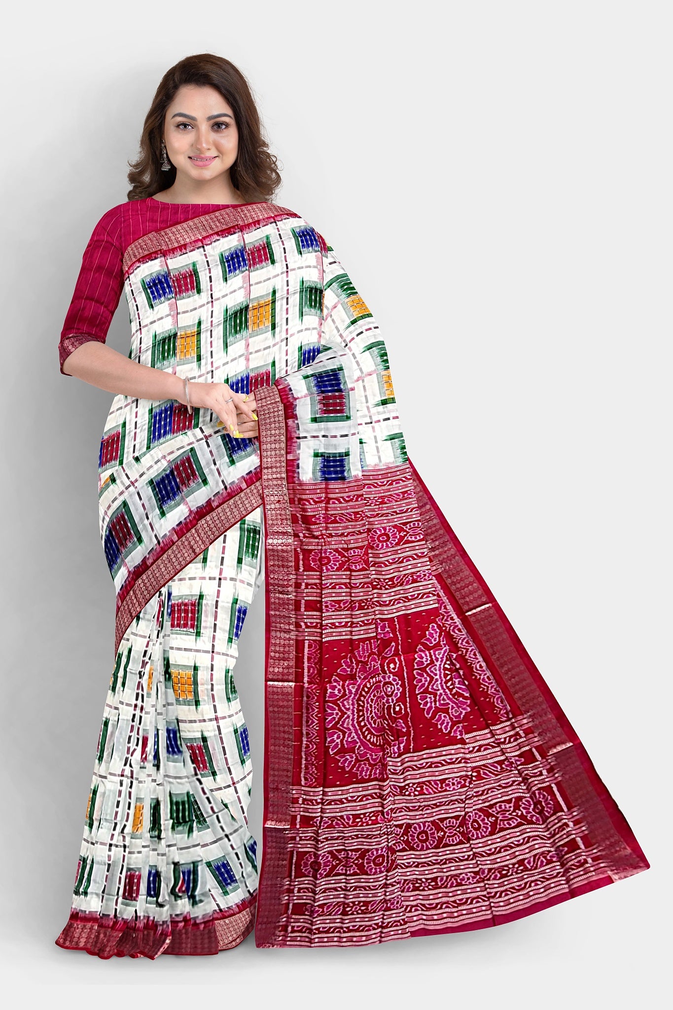 A stunning white and red saree featuring multicolor box patterns, a pallu adorned with conch (sankha), floral, and chakra motifs.