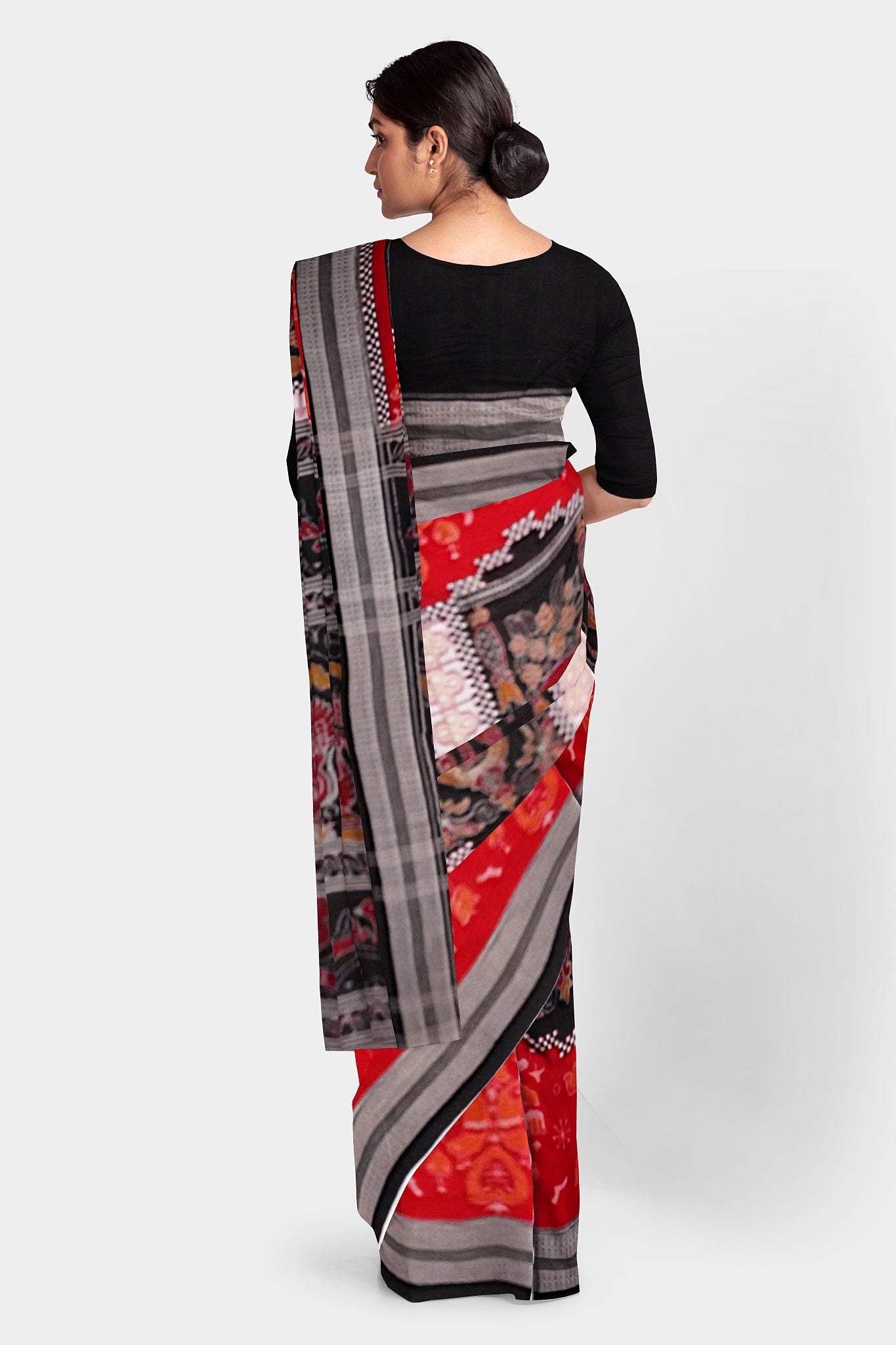 The red and black Sambalpuri cotton saree features a unique body pattern with small temples inside which are delicate duck motifs. The pallu is adorned with intricate designs of birds, dancers (Nartaki), and flowers.