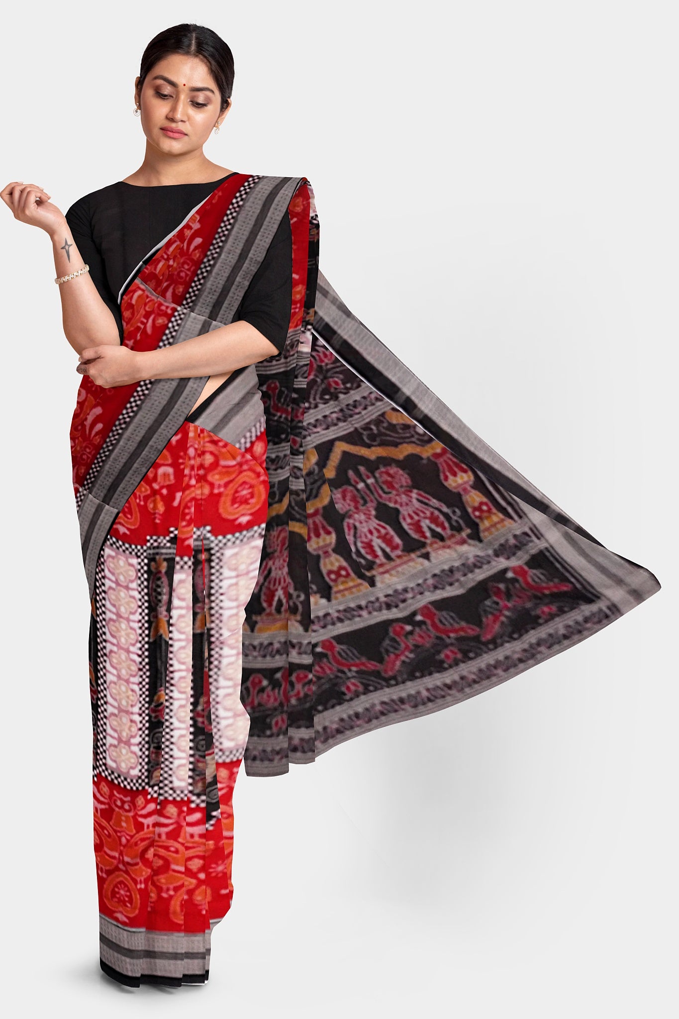 The red and black Sambalpuri cotton saree features a unique body pattern with small temples inside which are delicate duck motifs. The pallu is adorned with intricate designs of birds, dancers (Nartaki), and flowers.