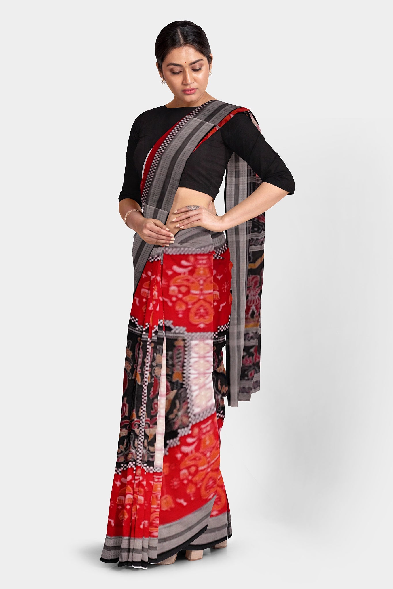 This orange and black Sambalpuri cotton saree features a temple, duck, and flower motifs on the body. The pallu showcases intricate designs of a dancer (nartaki), bird, lion, and the Konark chakra, blending cultural richness with artistic elegance.
