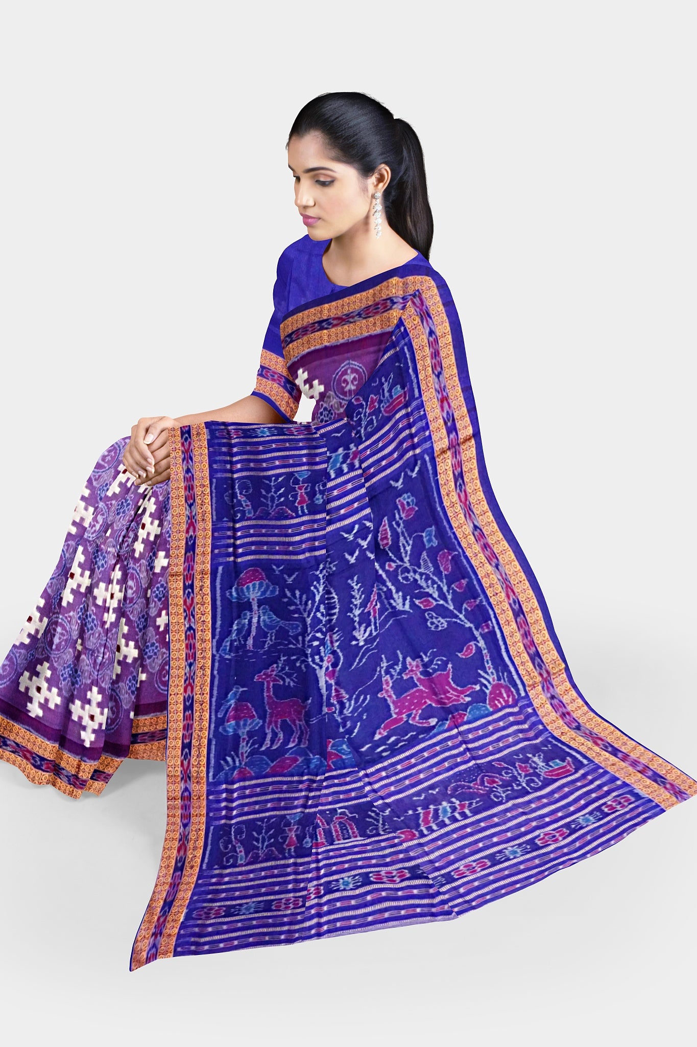 A Sambalpuri cotton saree with a purple and blue body featuring Nartaki, plus symbols, and a pallu design with elephants, trees, and birds.