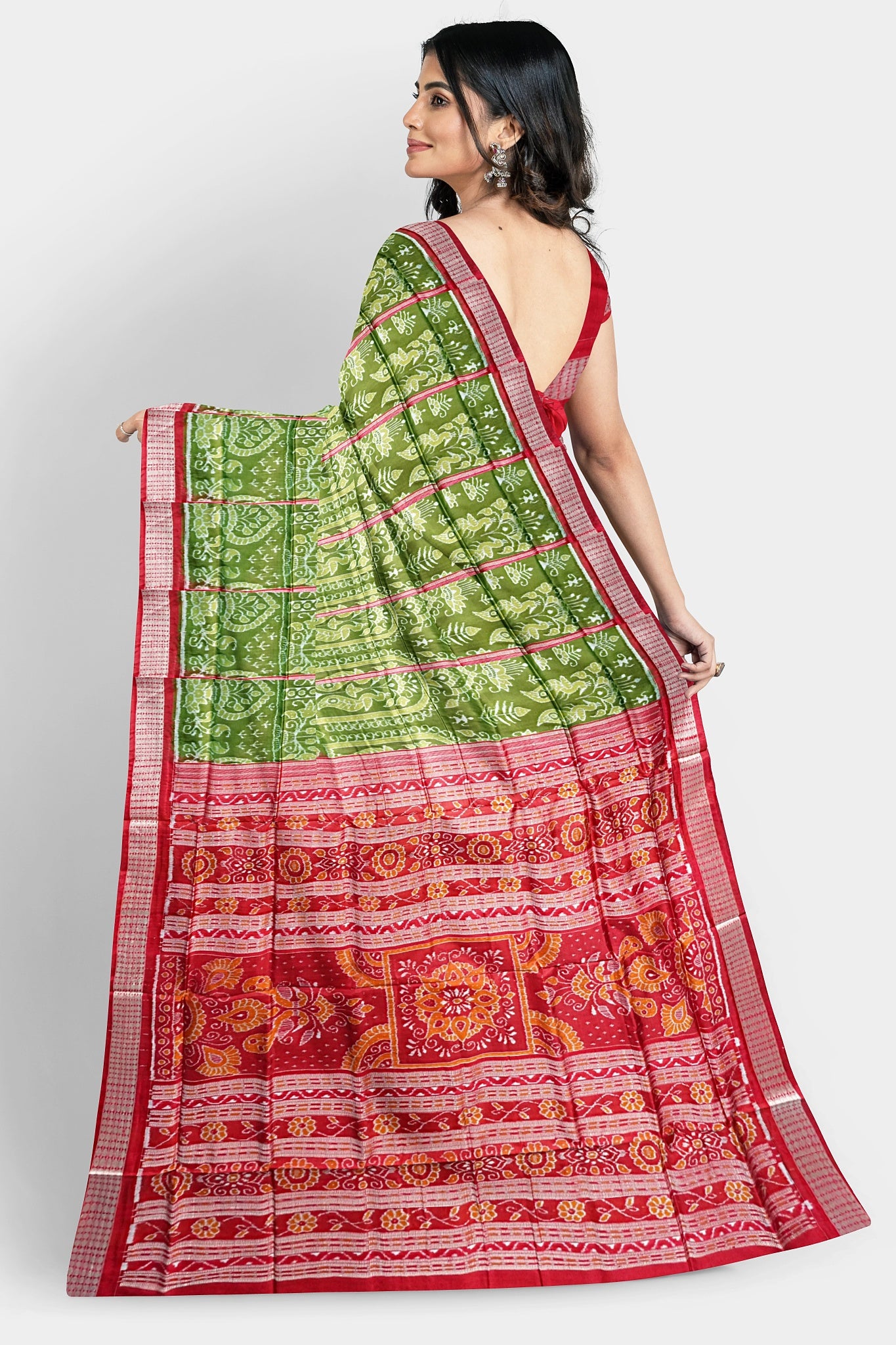 A deep green and red pure pata saree with nartaki and old design body pattern, and beautiful red flowers on the pallu.