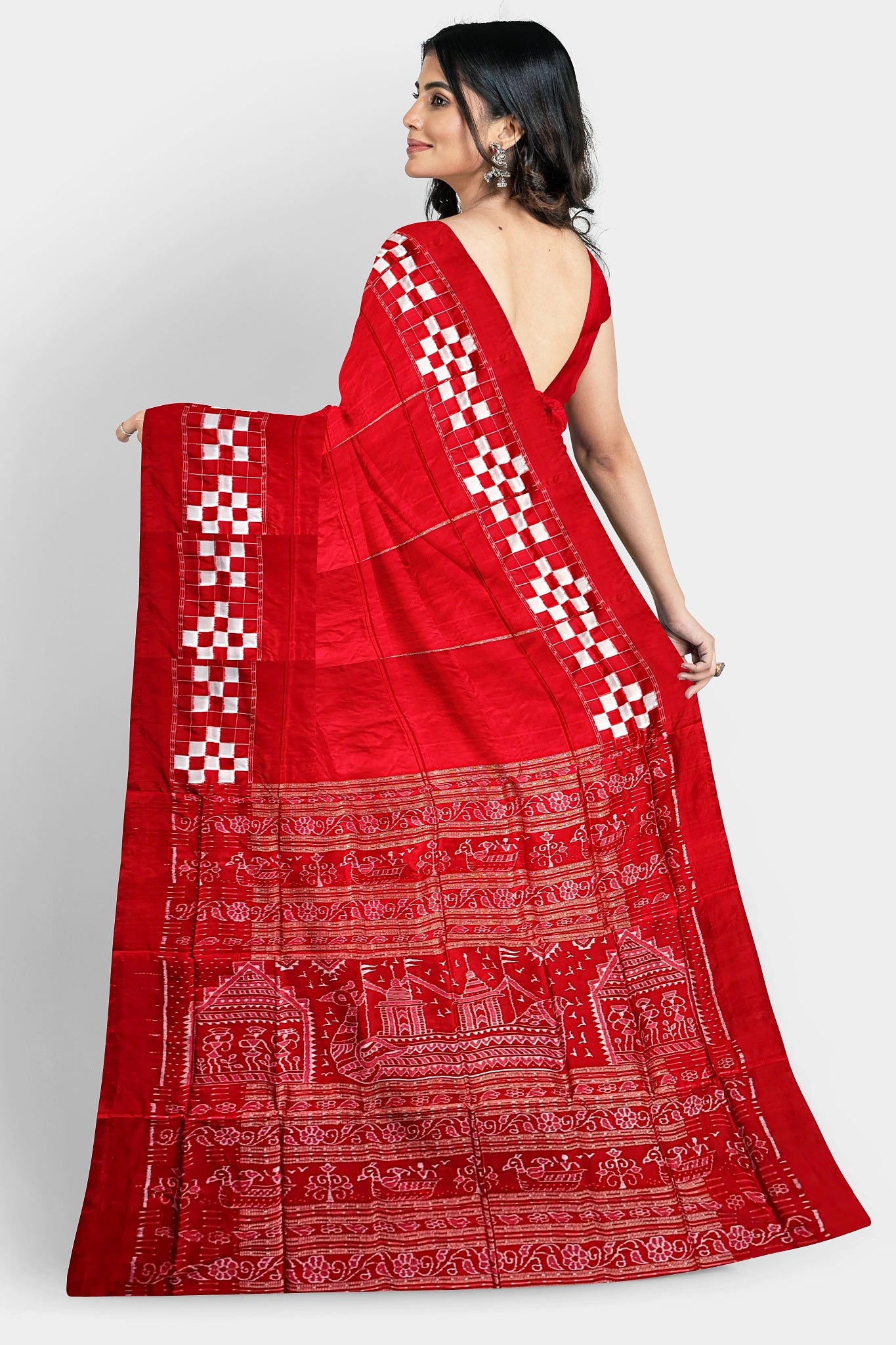 A red silk saree with a plain body, Passapli border, and a famous Boita design pallu featuring Adivasi patterns.