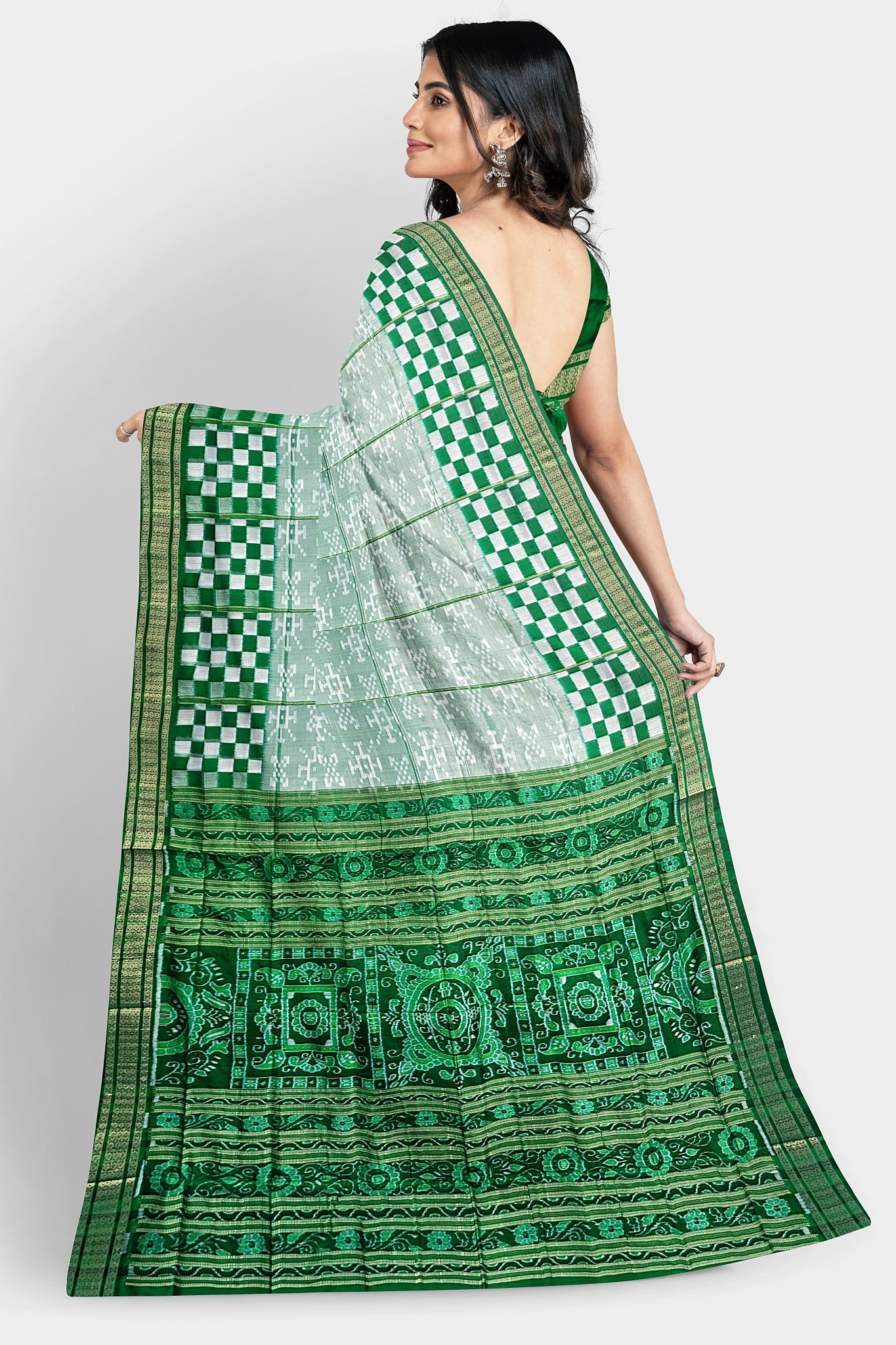 White and deep green pure Pata saree with drone design body, five-inch Pasapali border, and green pallu featuring elegant vine patterns.