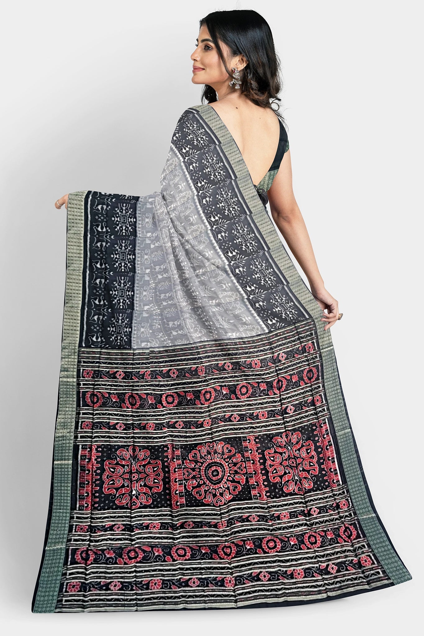 A pure shining Pata saree with a 5-inch black and light terracotta body pattern. The red pallu features three big flowers and vines.