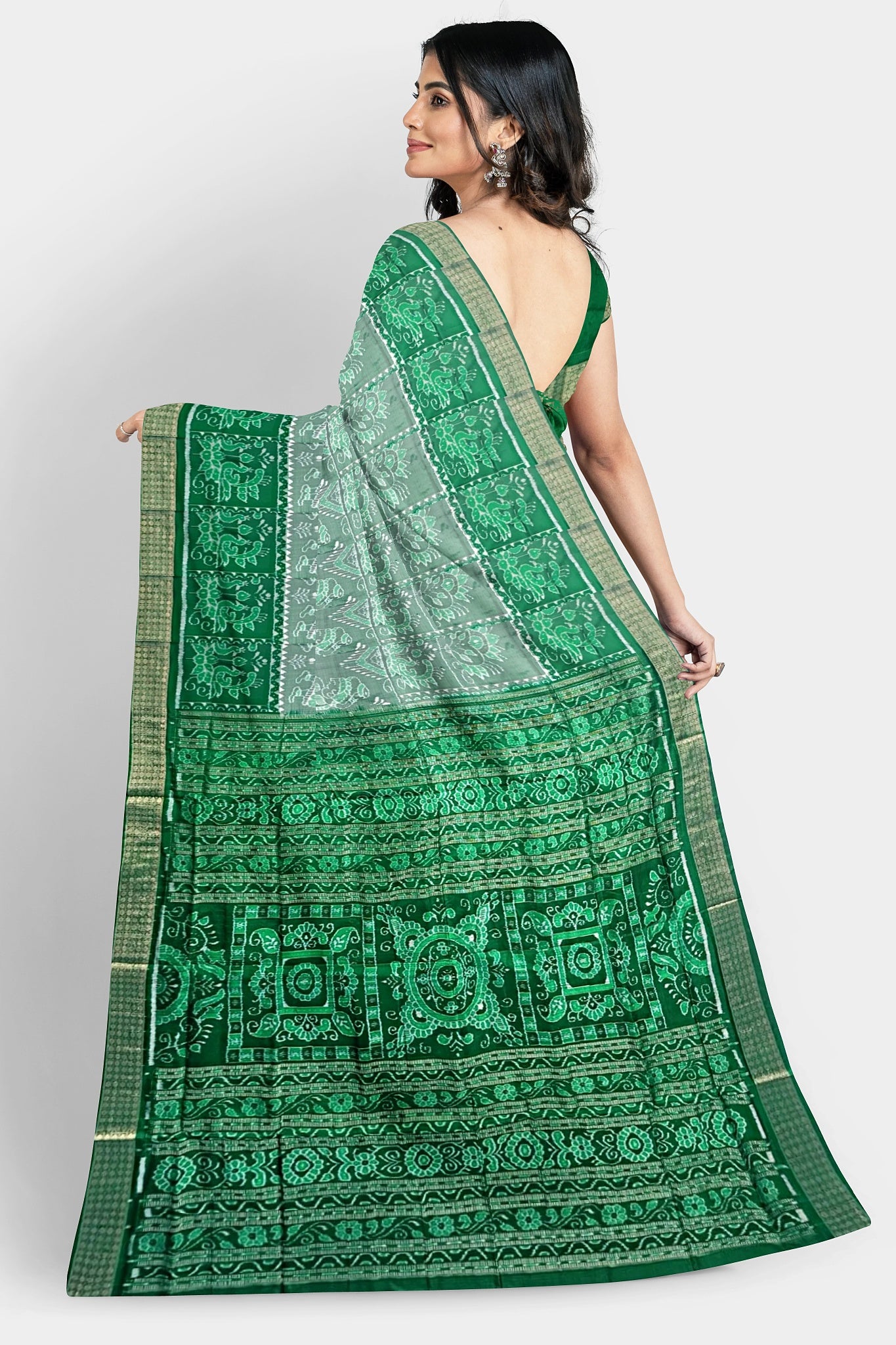 A white, deep green, and dark green pure shining Pata saree with Nartaki, peacock, and flower body pattern, and dark green pallu featuring three big flowers and vines.