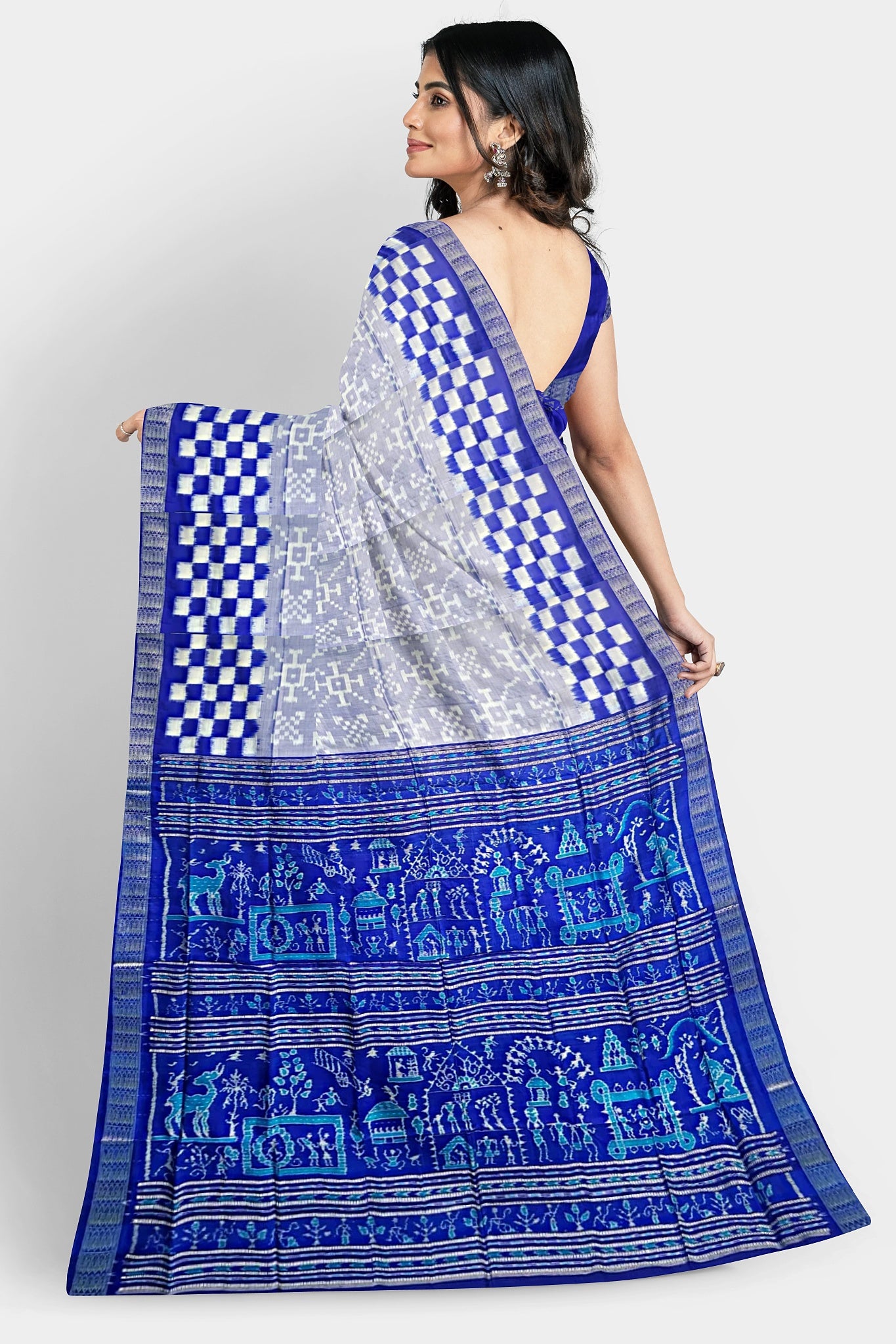 A white and blue pure Pata saree with a plain body, Pasapli border, and pallu featuring blue terracotta, house, beer, tree, cat, and duck designs.