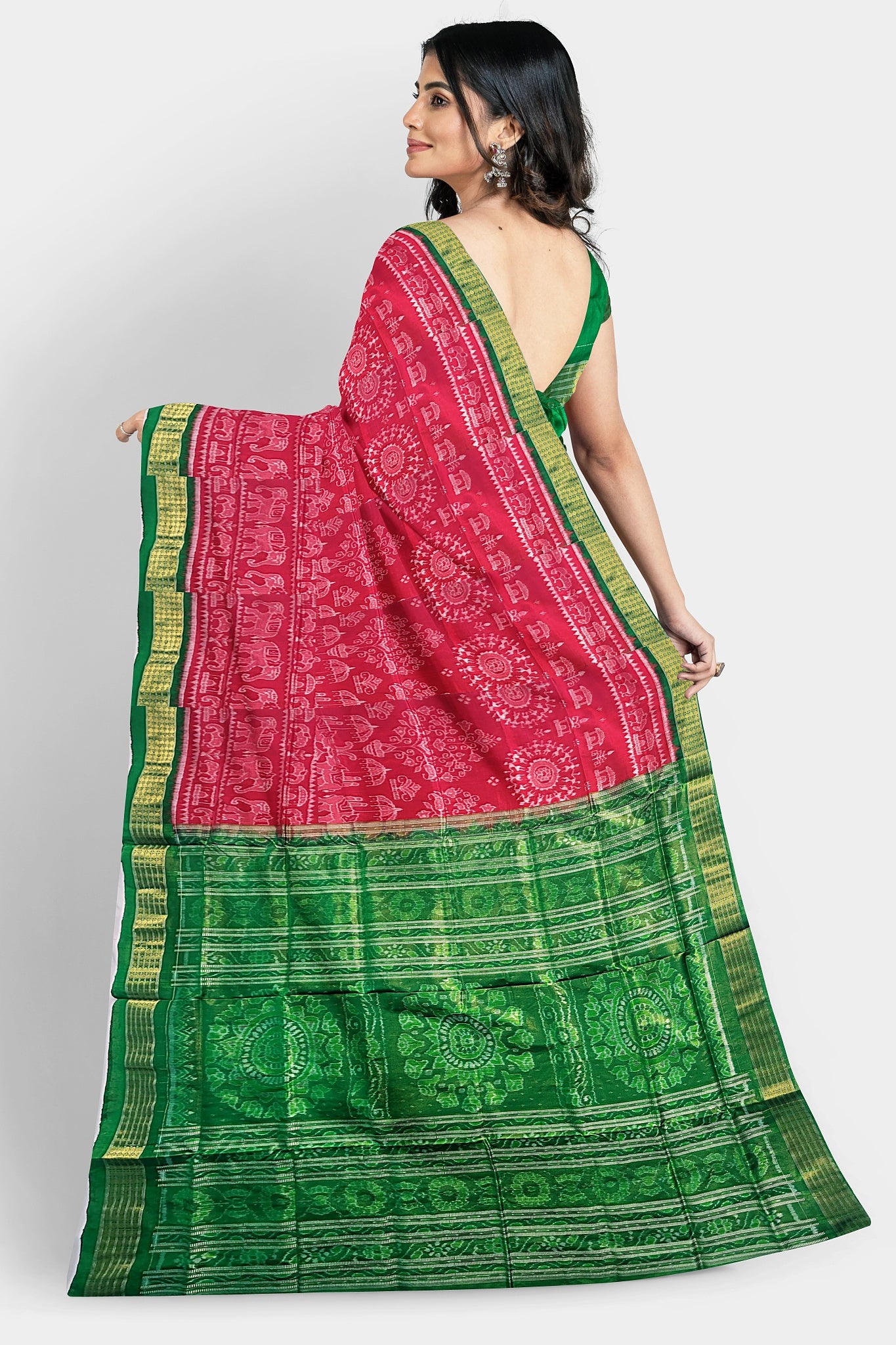 A pure Pata saree in red and green, featuring terracotta tree, elephant, and house motifs on the body, with floral and Sankha designs on the pallu.
