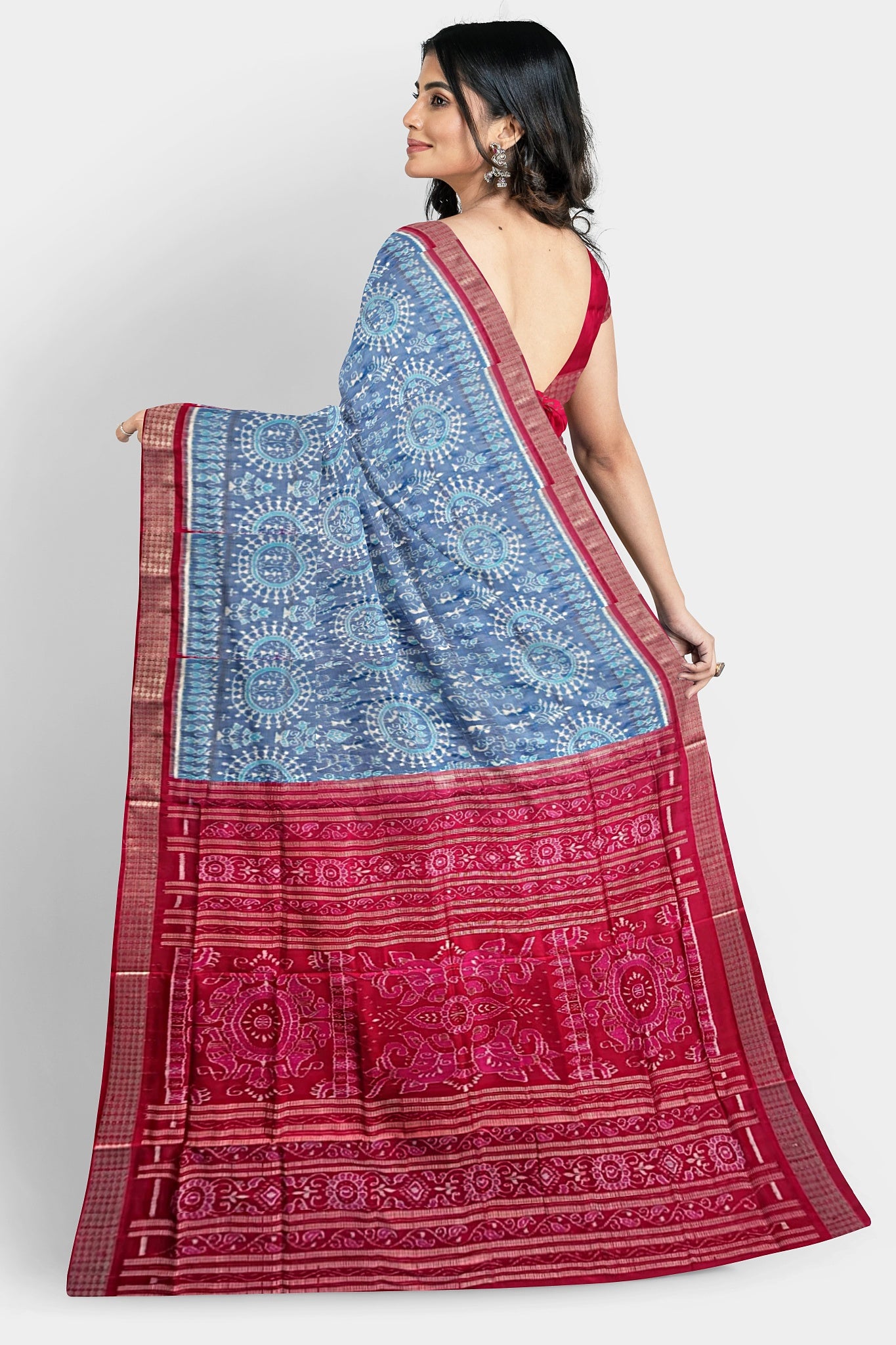 A sky blue and red shining pure Pata saree with terracotta small trees, big flowers, and pallu design featuring fish, vine, and bird.