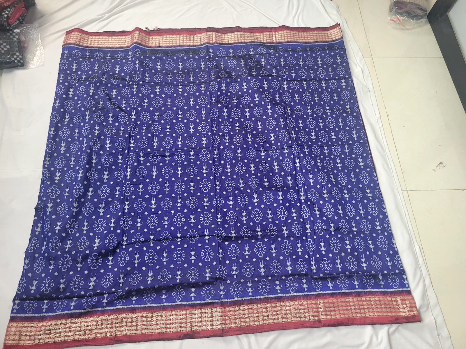 The maroon and blue color saree features a subtle body pattern with delicate designs and a pallu adorned with floral motifs.