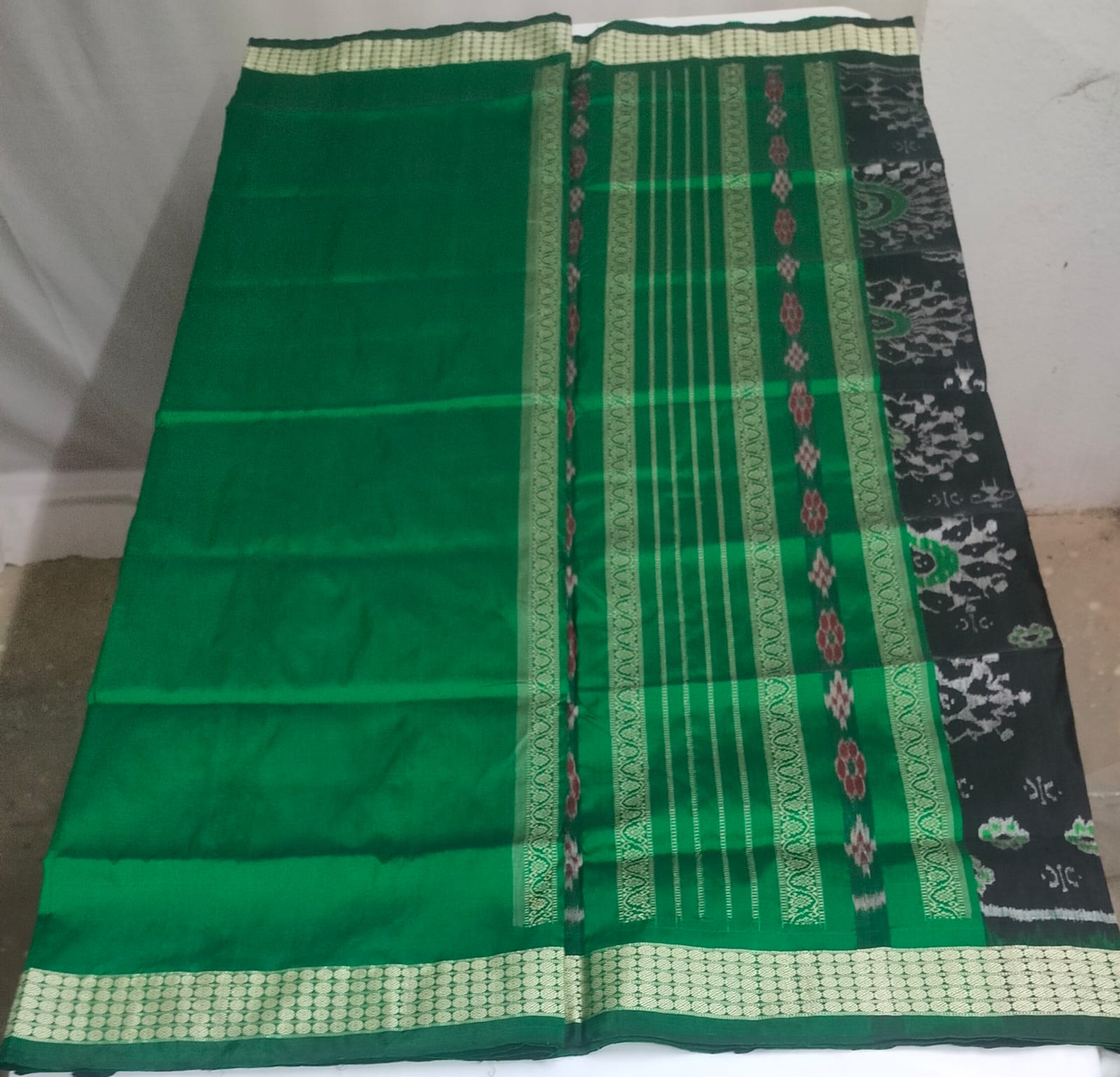Emerald green silk, adorned with black and green circular ikat motifs.