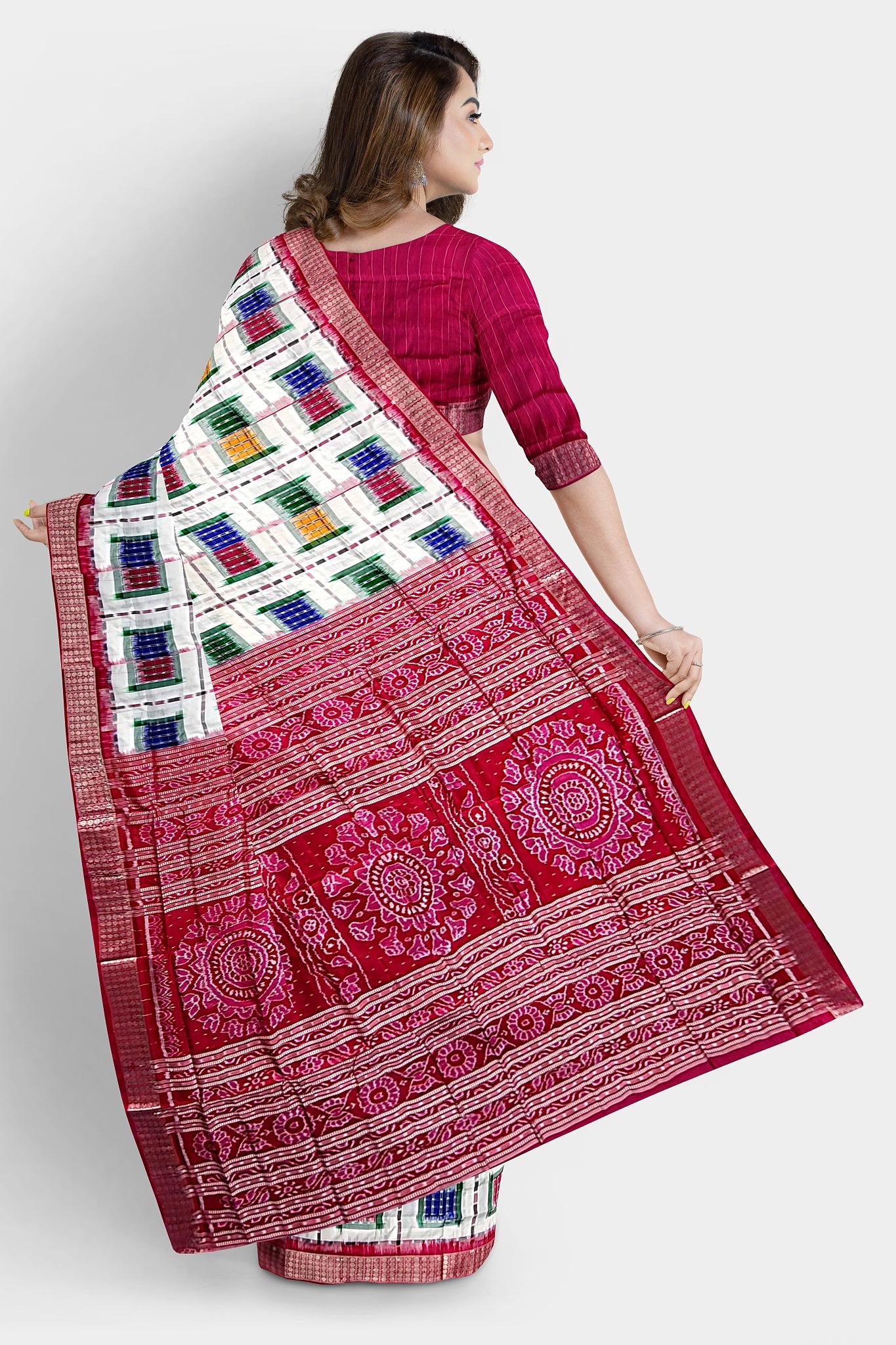 A stunning white and red saree featuring multicolor box patterns, a pallu adorned with conch (sankha), floral, and chakra motifs.