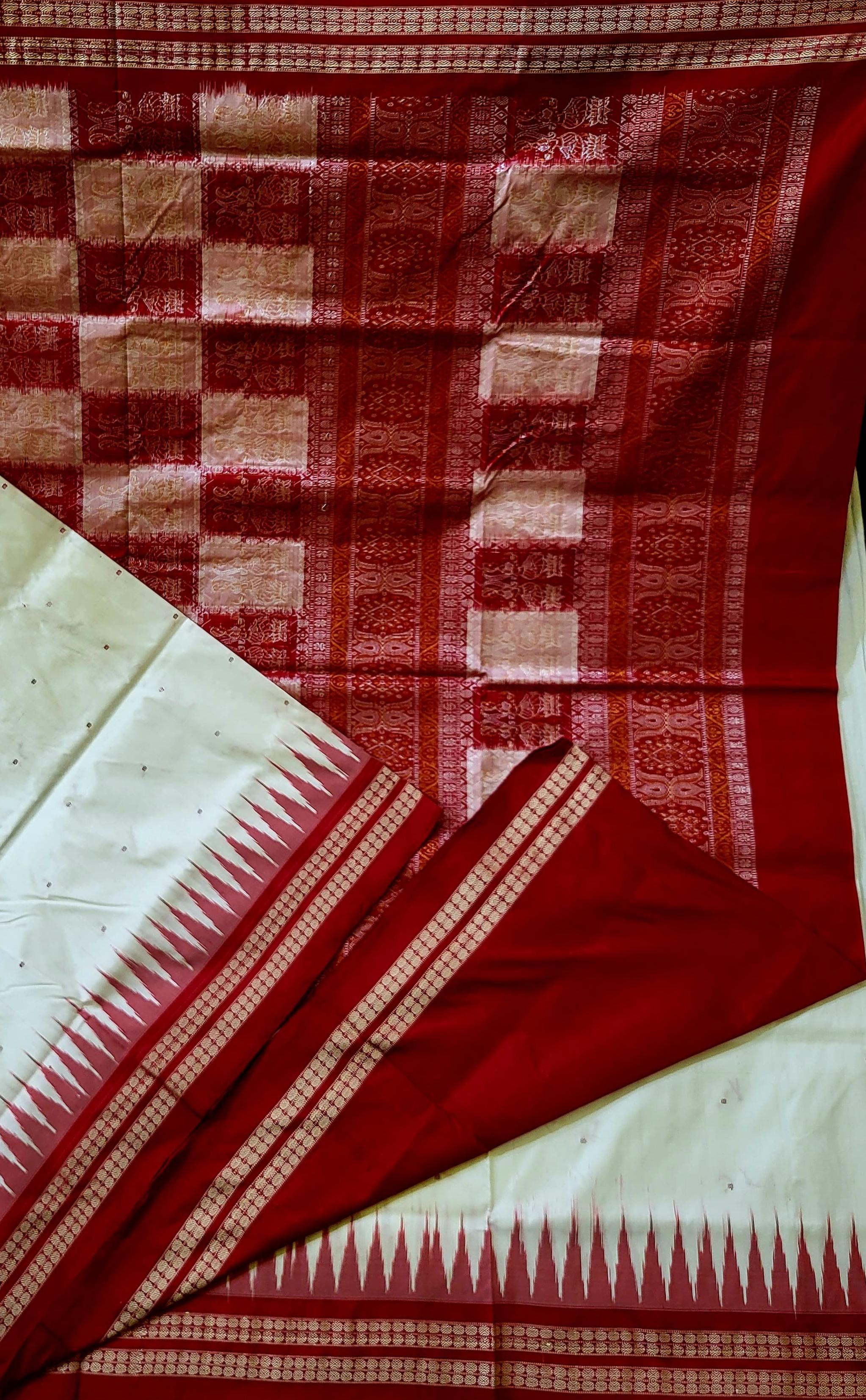 "Handwoven white and maroon Sambalpuri pure silk saree with bomkei pallu, complemented by a matching blouse piece. Elegant and traditional." - Koshali Arts & Crafts Enterprise